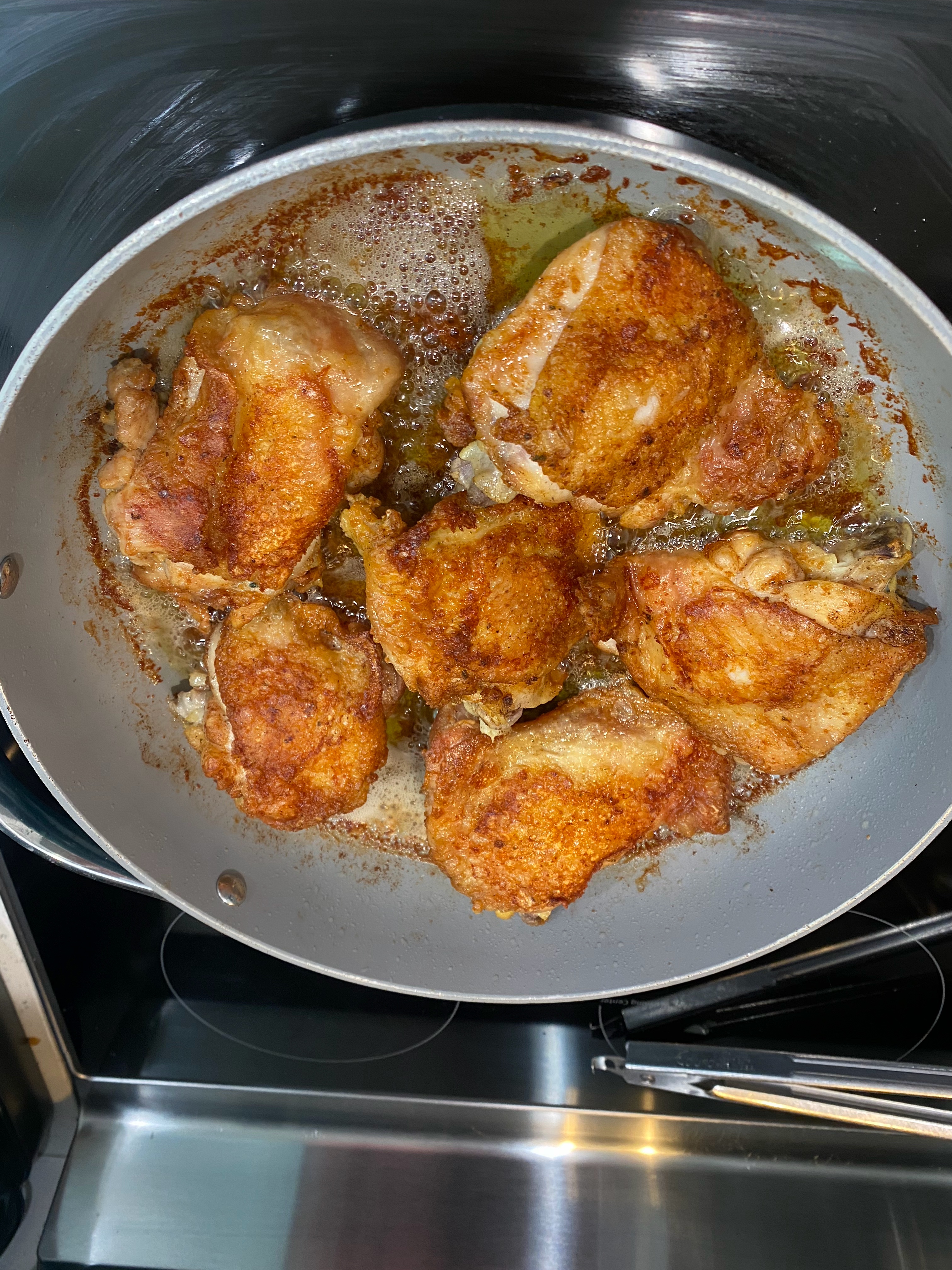 Ajla's chicken thighs searing in a hot pan, skin golden and crisp