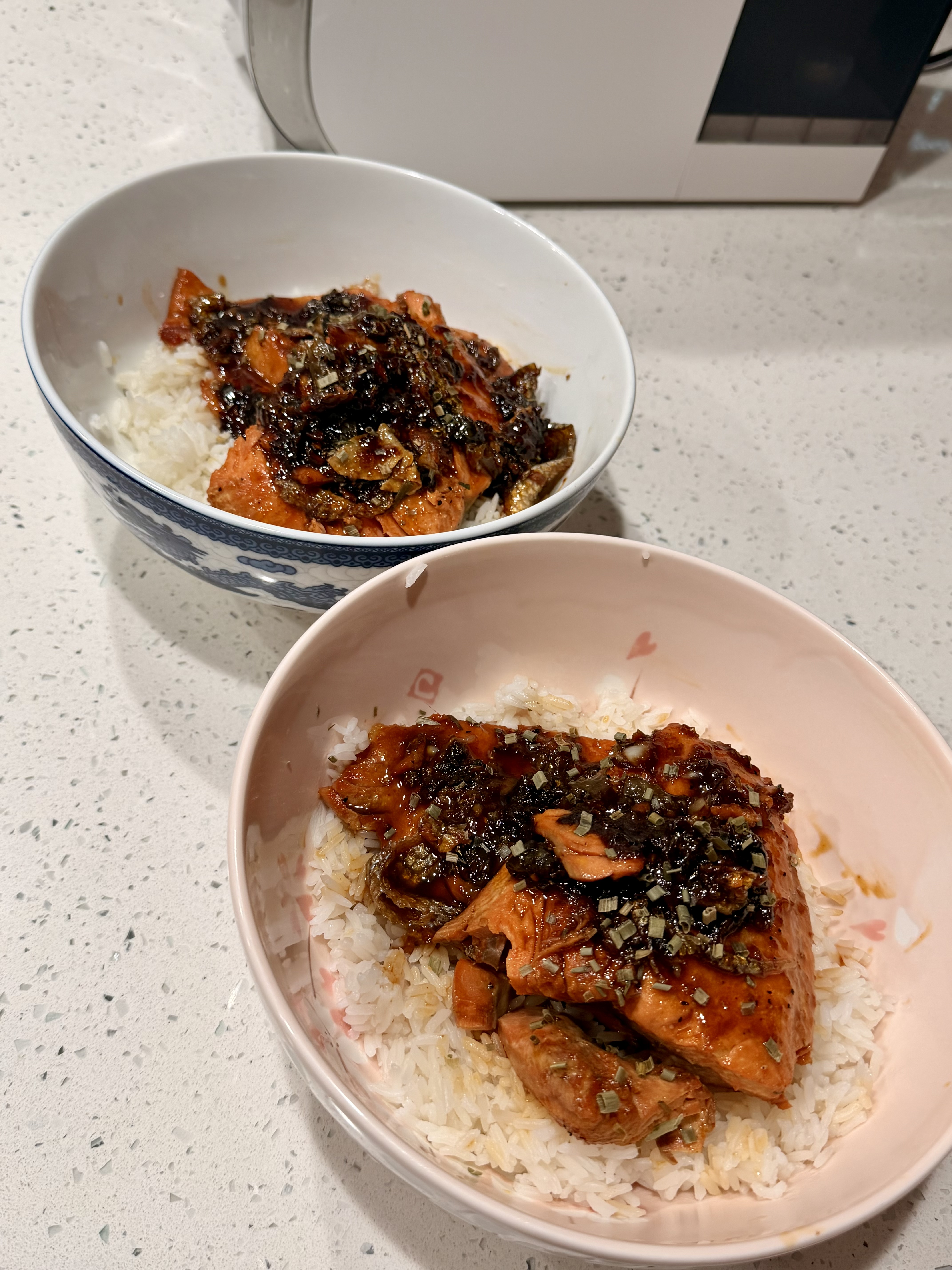 Two bowls of honey glazed salmon served over rice